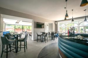 a restaurant with tables and chairs and a bar at Steventon House Hotel in Abingdon