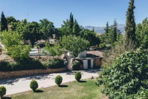 Blick auf einen Garten mit Bäumen und ein Haus in der Unterkunft Casas Cueva Tio Tobas Guadix in Alcudia de Guadix