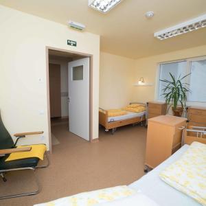 Habitación con 2 camas, escritorio y sillas. en Borbányai Rehabilitációs Ház, en Nyíregyháza