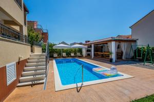 a swimming pool in the backyard of a house at Villa Julija in Kaštela