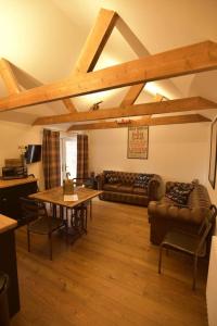 a living room with a table and couches and a table and chairs at The Stables at the Old Vicarage in Lincoln