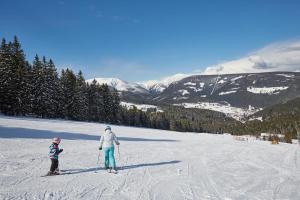 Ein Mann und eine Frau auf Skiern im Schnee in der Unterkunft Hostel KlonDike in Pec pod Sněžkou