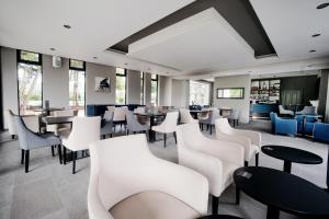 un restaurante con mesas y sillas blancas en Steventon House Hotel, en Abingdon