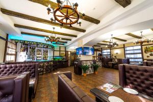 a restaurant with leather chairs and a bar at Adler in Astana