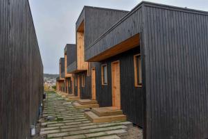 Une rangée de bâtiments noirs avec des escaliers entre eux dans l'établissement Cabañas Patio Esmeralda, à El Tabo