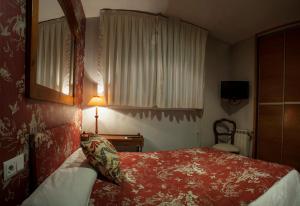 1 dormitorio con cama, escritorio y lámpara en Ch Hostal Victoria en Cuenca