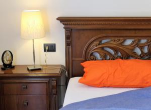 ソイアーノ・デル・ラーゴにあるB&B Drusilla Gardenのベッドルーム1室(オレンジ色の枕とランプ付きのベッド1台付)