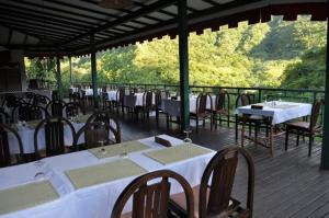 a restaurant with tables and chairs on a deck at Le Relais de la Maroto in Mariuti
