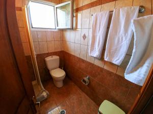 a small bathroom with a toilet and a window at Maria Apartments in Agios Georgios Pagon
