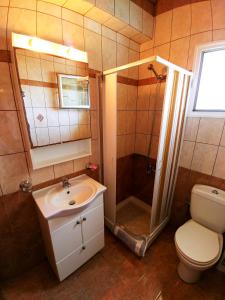 a bathroom with a sink and a shower and a toilet at Maria Apartments in Agios Georgios Pagon