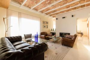 a living room with leather furniture and a fireplace at Hotel Boutique Ca l'Agustina in Preixéns