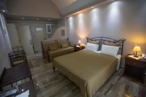 um quarto com uma cama grande e um sofá em Preka Maria em Kamari