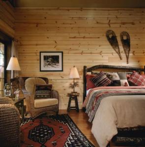 a bedroom with a bed, chair, desk and lamp at Cathedral Mountain Lodge in Field