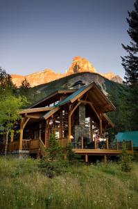 uma grande cabana de madeira com uma montanha ao fundo em Cathedral Mountain Lodge em Field