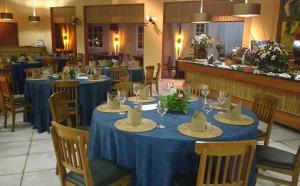 a restaurant with blue tables and chairs with hats on them at Ilha Flat Hotel-Ilhabela apart Schiavettii in Ilhabela