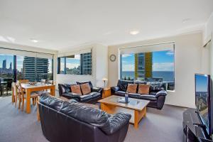 a living room with leather furniture and a view of the ocean at Mantra Broadbeach on the Park in Gold Coast