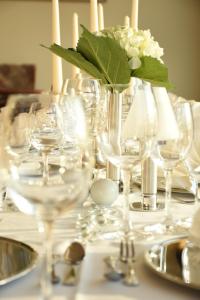 a table with wine glasses and a vase with flowers at City Hotel Suhl in Suhl