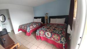 a hotel room with two beds and a table at Anchor Motel & RV Park in Surfside Beach +5 photos