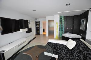ノハにあるBlack and White Suitte "Marques"のベッドルーム(ベッド1台、バスタブ、テレビ付)