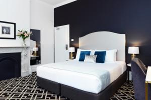 ein Schlafzimmer mit einem großen weißen Bett und einem Kamin in der Unterkunft High Cross Randwick by Sydney Lodges in Sydney