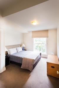 Un dormitorio con una cama grande y una ventana en The Terrace Villas Serviced Apartments en Wellington