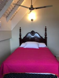 um quarto com uma cama com um cobertor rosa em #73 Fisherman's Point em Ocho Rios