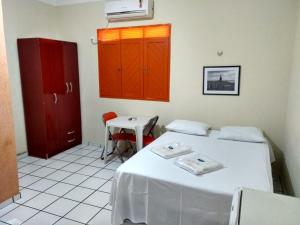a room with two beds and a table and cabinets at Pousada Terra do Sol in Caicó