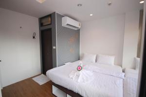 een slaapkamer met een wit bed met een bloem erop bij Darin Hostel in Bangkok +10 foto's