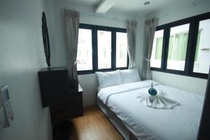 a bedroom with a bed with a vase on it at Darin Hostel in Bangkok