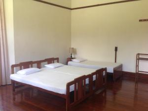 due letti in una stanza con pavimenti in legno di Morris Bungalow a Passara