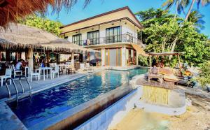 a resort with a swimming pool in front of a building at New Heaven Dive School and Resort in Ko Tao