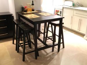 uma mesa de cozinha preta com bancos numa cozinha em Anna's Joye Seawind - Freeport, Montego Bay em Montego Bay