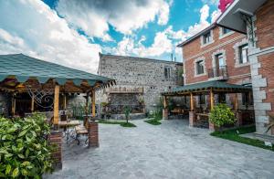 einen Innenhof eines Gebäudes mit Tischen und Bänken in der Unterkunft Hotel Tiflis in Achalziche