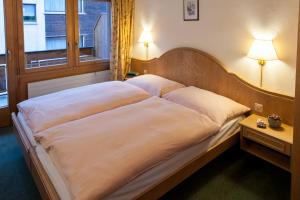 duże łóżko w pokoju z oknem w obiekcie Appartements Zermatt Paradies w mieście Zermatt