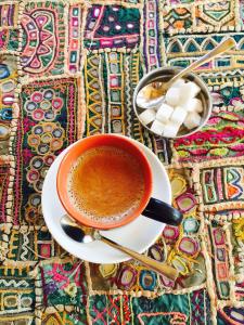 eine Tasse Kaffee auf einem Teller auf einem Tisch in der Unterkunft Hotel Garh Jaisal Haveli in Jaisalmer