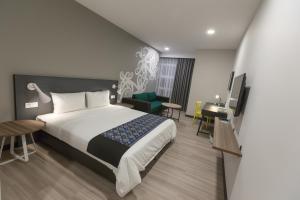 ein Hotelzimmer mit einem großen Bett und einem Schreibtisch in der Unterkunft Athome Boutique Hotel in Bintulu