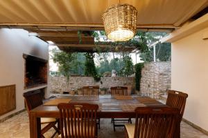 an outdoor dining room with a wooden table and chairs at Robinson House Nicolina in Hvar