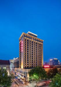 a tall building in a city at night at Hangzhou Xinqiao Hotel in Hangzhou