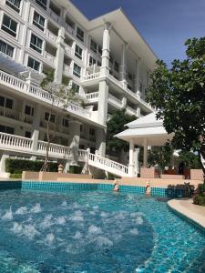 a swimming pool in front of a large building at The Energy Hua Hin by Jammaree in Cha Am