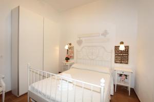 マラガにあるApartamento Olleríasのベッドルーム(白いベッド1台、白いベビーベッド付)