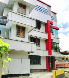 a building with red and white at Devanjana Inn Guruvayoor in Guruvāyūr