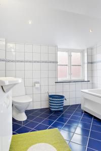 uma casa de banho com um WC, uma banheira e um lavatório. em Charming townhouse em Ystad