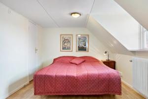 um quarto com uma cama rosa num sótão em Charming townhouse em Ystad