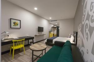 a hotel room with a bed and a desk and a couch at Athome Boutique Hotel in Bintulu +82 photos