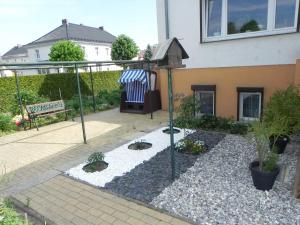 a garden with potted plants and a bench in front of a building at Ferienunterkuenfte Schulz in Ahlbeck