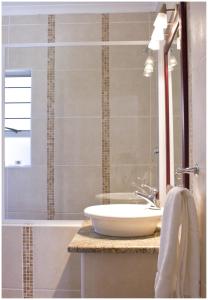 y baño con lavabo blanco y ducha. en Asante Guest House en Vanderbijlpark