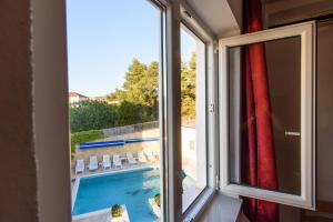 a window with a view of a swimming pool at Hotel B&B Villa Paula in Trogir