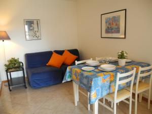 グラードにあるVilla Daniela Apartmentのリビングルーム(青いソファ、テーブル付)