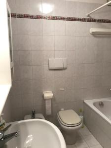 a bathroom with a toilet and a tub and a sink at Villa Daniela Apartment in Grado