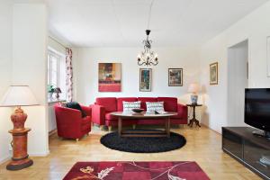 a living room with red couches and a table at Charming townhouse in Ystad